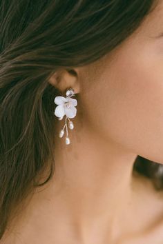 a woman wearing earrings with flowers on them