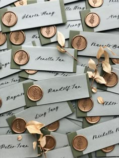 many different types of paper and gold coins with leaves on them, all labeled with name tags