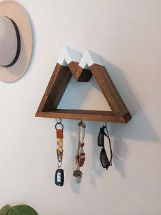 a hat hanging on the wall next to a clock with keys and keychains