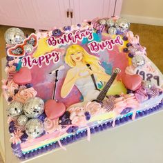 a birthday cake decorated with an image of a woman holding a guitar and surrounded by balloons