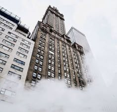 a tall building with lots of windows in front of it and steam coming out of the ground