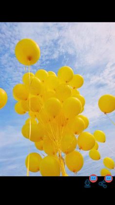 a bunch of yellow balloons floating in the air with blue sky and clouds behind them