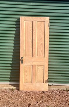 a wooden door sitting in front of a green wall