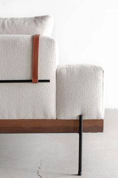 a white couch sitting on top of a wooden frame