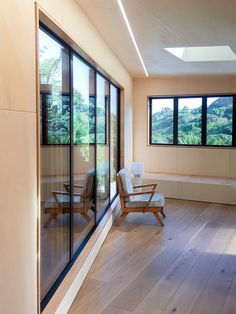 an empty room with wooden floors and large windows on the wall, looking out onto trees