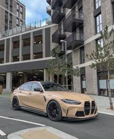 a beige sports car parked in front of an apartment building