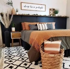 a bed with pillows and blankets in a bedroom next to a rug on the floor