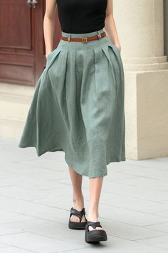 "This charming linen skirt in a muted green shade offers a fresh take on a classic A-line silhouette. The skirt's length is perfect, hitting just below the knees, making it versatile for various occasions.  More colors: https://etsy.me/3xgdqkM DETAIL * 100% linen  * Two seam pockets * Belt loops * Right zipper closure * No lining in side * Wash by hand or machine with cold water * Belt is not sale items * The model is 170cm (5′7″) tall with a 80cm (31.5\") bust, 66cm (26\") waist. She is wearing Elegant Green Pleated Skirt For Summer, Pleated Linen Long Skirt, Elegant Full Linen Skirt, Green A-line Maxi Skirt For Summer, Pleated Full Linen Skirt, Elegant Linen Gathered Skirt, Pleated Flowy Linen Skirt, Green Knee-length Pleated Skirt For Summer, Pleated Linen Flared Skirt