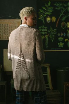 a woman standing in front of a chalkboard with plants on it and writing on the wall