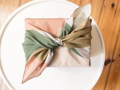 a white plate topped with two napkins on top of a wooden table