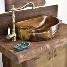 a wooden sink sitting on top of a wooden counter next to a faucet