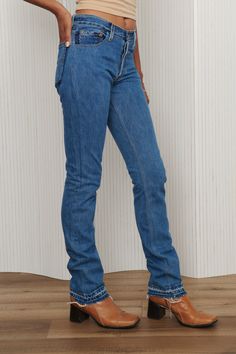 A unique pair of Levi's reworked denim jeans - featuring two tone pockets, frayed and exposed hem, and button fly. 100% Cotton. Waist: 27” - Hips: 36” - Rise: 9.5” - Inseam: 36” - Leg Opening: 7”. Fits like 26-27. Model is waist size 26. Full Length Rigid Denim Flare Jeans With Frayed Hem, Frayed Hem Rigid Denim Jeans, Frayed Hem Full Length Rigid Denim Jeans, Dark Wash Flare Jeans With Contrast Stitching, Rigid Denim Jeans With Contrast Stitching, Standard Cut, Trendy Levi's Rigid Denim Bottoms, Fitted Rigid Denim Flare Jeans In Dark Wash, Fitted Dark Wash Flare Jeans In Rigid Denim, Fitted Rigid Denim Jeans In Denim Blue