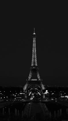 the eiffel tower lit up at night in black and white with text overlay