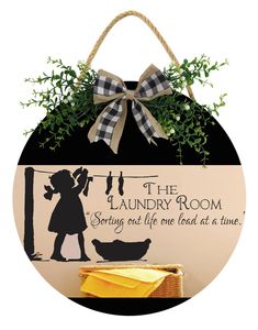 the laundry room sign with a bow hanging from it's side and an image of a woman holding a broom