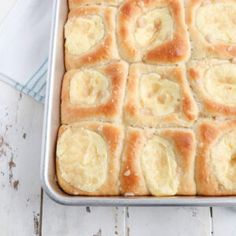 a pan filled with baked bread on top of a wooden table