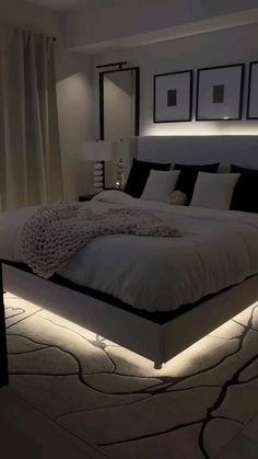 a large bed sitting in the middle of a bedroom next to two lamps on either side of it