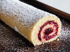 a pastry with powdered sugar and cranberry filling on it's side