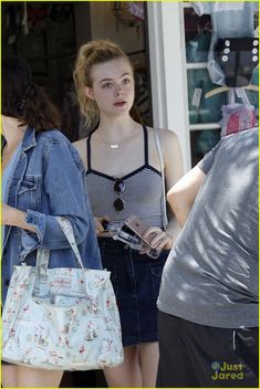 a woman with a handbag is standing in front of a store