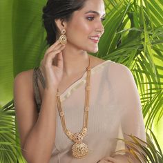 The gold beaded chain necklace that sizzles the room, this long necklace is royal charm. Excellent to pair with a kanjivaram or handloom saree. Specification: Weight - 100 gm (necklace); 19 gm (earring); Length - 36 cm (necklace); 8 cm (earring), 100% Satisfaction Guarantee:  1 Year Warranty, Long Lasting Plating, High-Quality Stones. Gifting:  This Indian long necklace set comes in a beautiful Tarinika gift box, making it an ideal gift for birthday, wedding anniversary or wedding gift.  Occasion: Perfect choice for any Indian occasion.  Care: It is advisable that you keep Tarinika products away from direct heat, humidity, and moisture. It is best to preserve your Tarinika jewelry in the box. Return/Exchange Policy:  We provide 14 days return/exchange policy. Contact us for any questions. Indian Long Necklace, Indian Jewelry Set, Long Necklace Set, Necklace Set Indian, Modern Gold Jewelry, Gold Jewelry Simple Necklace, Gold Necklace Indian, Gold Necklace Indian Bridal Jewelry, Gold Chain Design