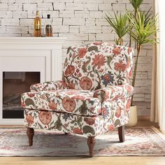 a chair sitting in front of a fireplace with a potted plant next to it