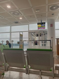 two people sitting at an airport waiting for their luggage