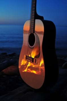 a guitar sitting on top of a rock next to the ocean with words that read, yeels geluk