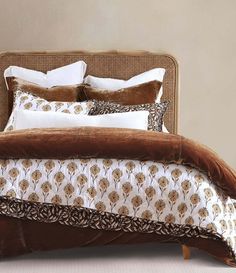 a bed with brown and white pillows on top of it