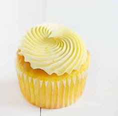 a yellow cupcake with white frosting on top