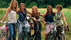 the girls are posing with their bikes outside