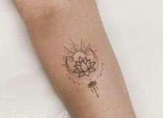 a person with a tattoo on their arm that has a lotus flower and sun in the middle