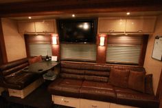 a living room with leather couches and a flat screen tv mounted to the wall