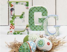 the letters are decorated with flowers and birds on them, along with eggs in hay