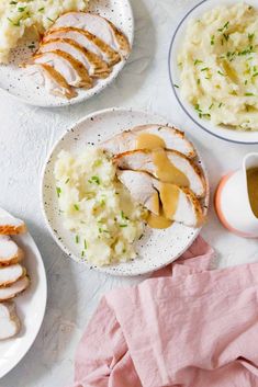 three plates with chicken, mashed potatoes and gravy next to a cup of tea