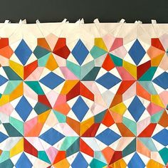 an art project made out of colored paper with different shapes and sizes on the wall