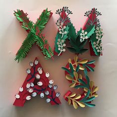 four paper christmas trees on a white surface