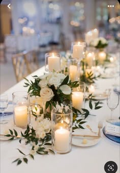 a long table with candles and flowers on it is set up for a formal dinner