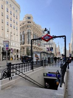 a street scene with focus on the sidewalk and buildings in the background, as well as people walking around