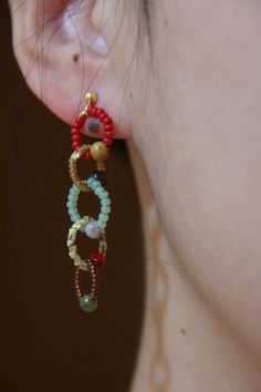 a close up of a person's ear with beads on it and earrings attached to them