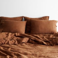 a bed with brown sheets and pillows on it