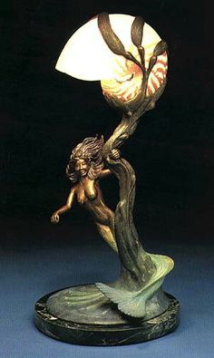 a figurine of a girl holding a lamp on top of a base,