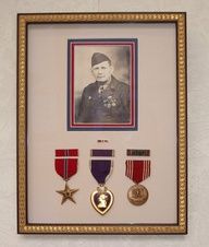 a framed photo with medals and a star