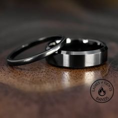 two wedding rings sitting on top of a wooden table