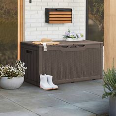 a brown cooler sitting on top of a patio next to a potted planter