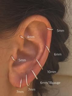 an ear with three different types of piercings on it, and the measurements for each one