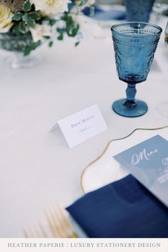 the table is set with place cards and wine glasses