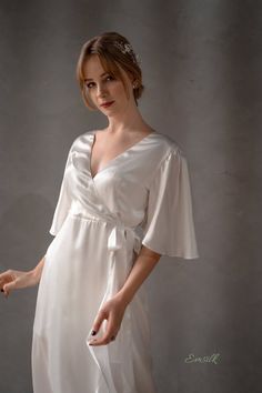 This luxury exclusive design is perfect as a simple wedding outfit. 100 % designed and handmade by Emsilk. I am pleased to offer your garments made to measure at no extra cost. All of my designs can be made in any colors that you see in my shop. * Detail: - Wrapped Deep V neckline front and back- Large Ruffle sleeves- Silk belt straps on waist- Ruffle wrapped pencil bottom- Invisible side zipper- Floor length- Fully lined-Best quality silk, 100 % pure 19mm Mulberry Silk in ivory white which is m Silk Wedding Dress With Draped Sleeves, Elegant Silk Summer Gown, Satin Wedding Dress With Draped Sleeves, Elegant Silk Satin Dress With Ruffles, Wedding Night Satin Dress With Ruffles, Feminine Wedding Dress With Satin Finish, Chic Silk Wedding Dress With Satin Finish, Chic Silk Dress With Satin Finish For Wedding, Chic Silk Dress For Wedding