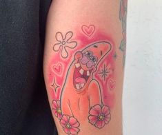 a woman with a tattoo on her arm has an image of a cartoon character and flowers