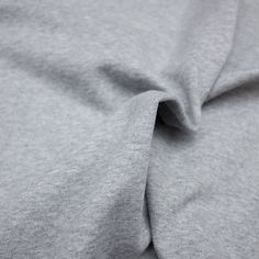 a close up view of the fabric on top of a grey shirting material,