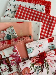 many different types of fabric are laid out on a table top with red and white checkered cloths