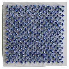 blue beads are arranged on a white surface